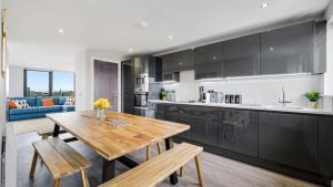 利物浦Host & Stay - The Baltic Penthouse 2的厨房以及带木桌的用餐室。