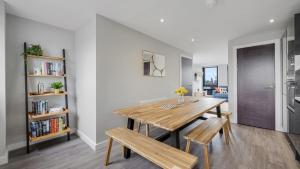 利物浦Host & Stay - The Baltic Penthouse 2的一间带木桌和长凳的用餐室