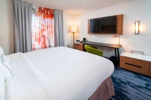 本德本德市中心费尔菲尔德套房客栈的酒店客房设有一张白色大床和一张书桌