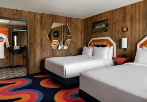 弗拉格斯塔夫Americana Motor Hotel的酒店客房带两张床和两面镜子