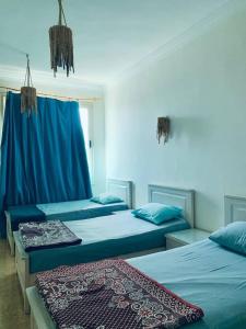 达哈布Luna House Lighthouse的一间设有两张蓝色床单的床的房间