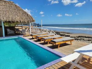 里瓦斯AZVLIK的一个带长椅和海滩的游泳池