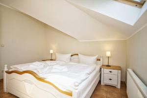 洛默Ferienwohnung mit traumhaftem Meerblick - Haus am Meer FeWo 12的卧室配有白色的床和天窗