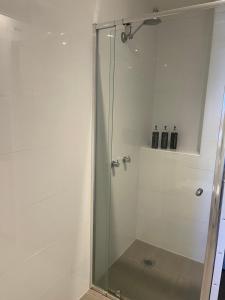 库马Cooma Hotel的浴室里设有玻璃门淋浴
