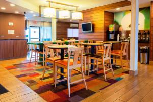 Ponca City万豪庞卡城市酒店费尔菲尔德客栈的一间设有桌椅的餐厅,铺着色彩缤纷的地毯