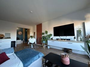 里尔LILLE Appart Cosy 68m2 lumineux avec balcon - garage prive的客厅配有床和平面电视