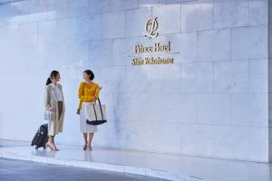 横滨新横滨王子大饭店(Shin Yokohama Prince Hotel)的两名妇女站在白色墙前