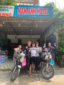 峰牙Nam Anh Hotel的一群站在摩托车前面的人