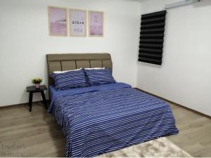实兆远[FREE WI-FI]Travelers Homestay Sitiawan[6~10Pax]The Venus Apartment的卧室内的一张带蓝色和白色条纹棉被的床