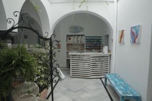 塔里法Wake up in Tarifa Hostel & Restaurant Lounge的一间设有拱门和蓝色长凳的商店