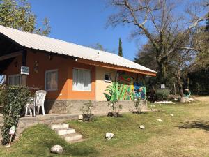 萨尔塔Wara Kusi cottages, in Salta Argentina的前面有椅子的房子