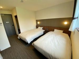 朝来市Crest Asago的配有白色床单的酒店客房内的两张床