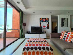 考陶Las Tortugas, Cozy condominium on Khao Tao beach, Hua Hin的一间带床和电视的客厅