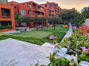 考陶Las Tortugas, Cozy condominium on Khao Tao beach, Hua Hin的享有公园美景,公园内有建筑和鲜花