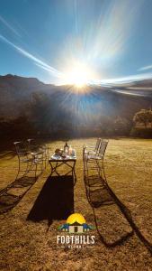 布什格尔Foothill Pushkar Resort的太阳前的两把椅子和一张桌子
