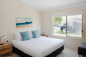 伦诺克斯角Reflections Lennox Head - Holiday Park的一间卧室设有一张大床和一个窗户。