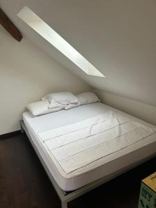 卢塞恩M-Hostel的一张带白色床单和枕头的床