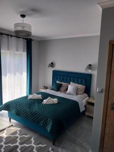 乌斯特卡VILLA EDEN USTKA wypoczynek dla dorosłych的一间卧室配有一张蓝色床头板的床
