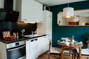 耶拿Design Home Office & Central Hideaway - EAH, ZEISS, SCHOTT in 5 min的厨房配有白色橱柜和小桌子