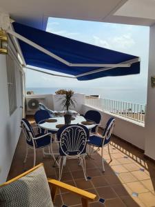 莫哈卡尔Residential Oasis 25的阳台配有桌椅,享有海景。