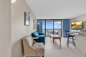 默特尔比奇Hosteeva Beach View 1BR Ocean Forest Plaza Condo的客厅配有蓝色的沙发和桌子