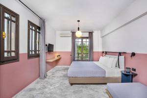 帕利乌里翁Estival Concept的卧室设有粉红色和白色的墙壁和1张床