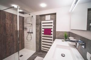 圣加伦基希Alpenherz Apartments的带淋浴和白色盥洗盆的浴室