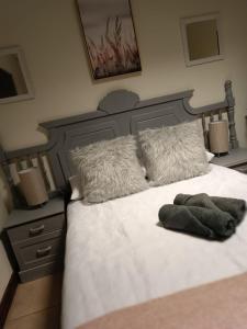 布隆方丹Bello Guest的卧室配有一张带白色床单和枕头的大床。