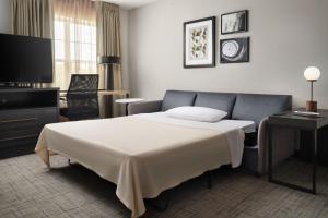 斯坦霍普国际贸易中心橄榄山原住客栈的酒店客房,配有床和电视