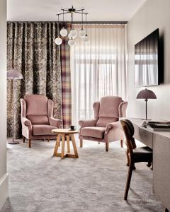 拉多姆Hoppen House Apartamenty w centrum miasta的客厅配有两把椅子和一张桌子