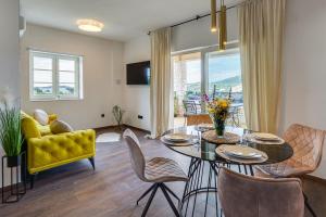 萨利TEONA Luxury Apartment with 2 rooms and terrace sea view的客厅配有餐桌和黄色沙发