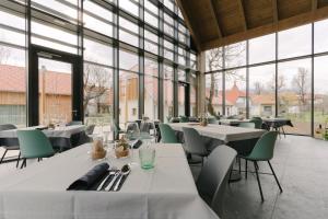 波斯托伊纳PIRA HOTEL的餐厅设有桌椅和大窗户。