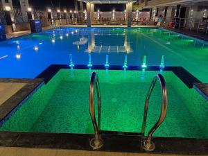 曼达莫尼Royal Palace Beach Resort的水中灯火的大游泳池