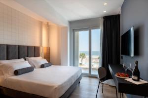 里乔内Hotel Sporting Riccione的一间卧室配有一张床,享有海景