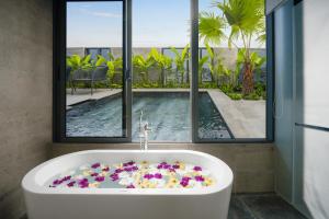 岘港Estrella Boutique Hotel的浴室配有带鲜花的浴缸。