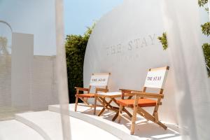 考陶The Stay Huahin - Luxury Private Pool Villa的大楼前的两把椅子和一张桌子