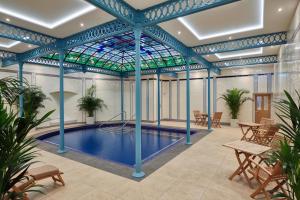 巴克斯顿Ensana Buxton Crescent的一个带彩色玻璃天花板的游泳池和一个游泳池