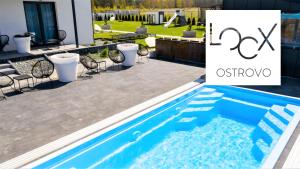 奥斯特罗沃Loox Ostrovo- Boutique House-noclegi nad morzem的庭院中的游泳池,庭院和房子