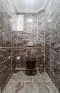 伊斯坦布尔Manu Startup House的设有带黑色浴缸和大理石墙壁的浴室。
