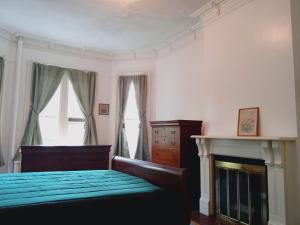 普兰菲尔德Mini Mansion Hotel affordable stays Plainfield NJ near public transportation的一间卧室配有一张床和一个壁炉