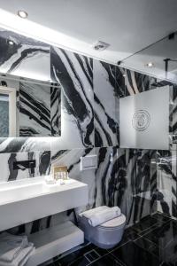 埃尔莫波利斯Pafsilipon Suites的黑白浴室设有水槽和卫生间