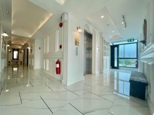 清迈Wiang Ville Boutique Hotel的大型走廊设有白色瓷砖地板和消防栓