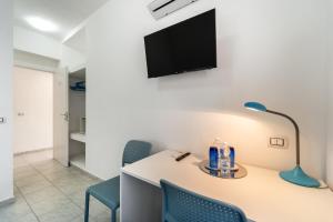 卡尔博尼亚B&B il Rifugio的配有桌椅和墙上电视的房间