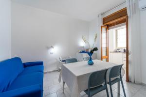 卡尔博尼亚B&B il Rifugio的一间带桌子和蓝色沙发的用餐室