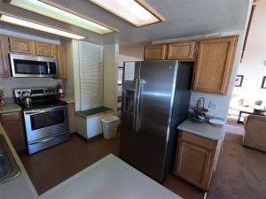 六月湖Rr-edgewater13的厨房配有不锈钢冰箱和木制橱柜