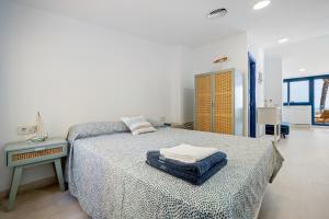 卡拉费尔Calafellmar loft的白色卧室配有床和桌子