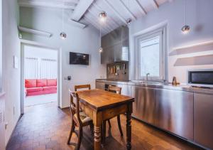 佛罗伦萨CountryHouse con Piscina Privata Vicina al Centro的厨房配有木桌和红色沙发。