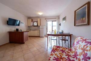普罗基奥Villa Cecilia - Appartamenti的带沙发的客厅和带桌子的厨房