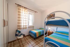 普罗基奥Villa Cecilia - Appartamenti的一间卧室配有两张双层床和椅子