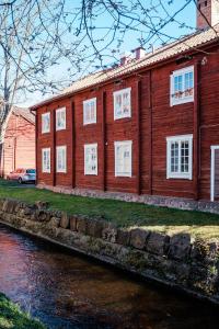 埃克舍Vandrarhemmet Färgaren的一座木结构建筑,设有白色窗户,毗邻一条河流